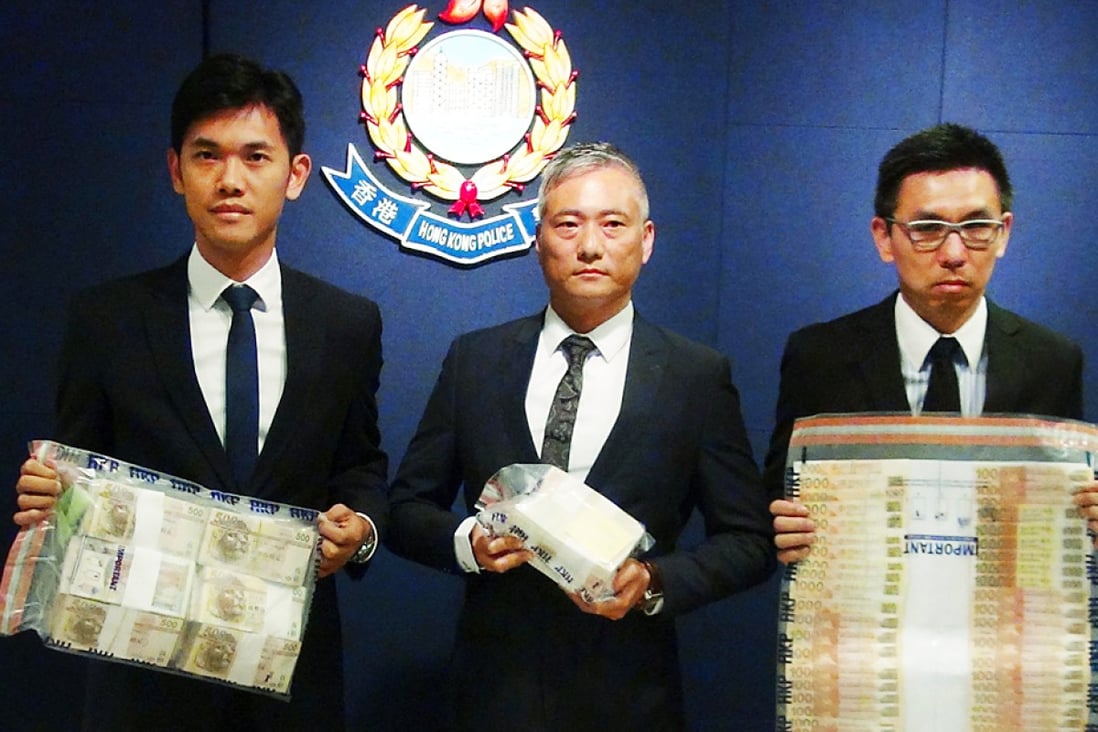 Police including Superintendent Dan Ng (centre), seized cash, luxury watches and computers in Sunday's raids. Photo: SCMP 