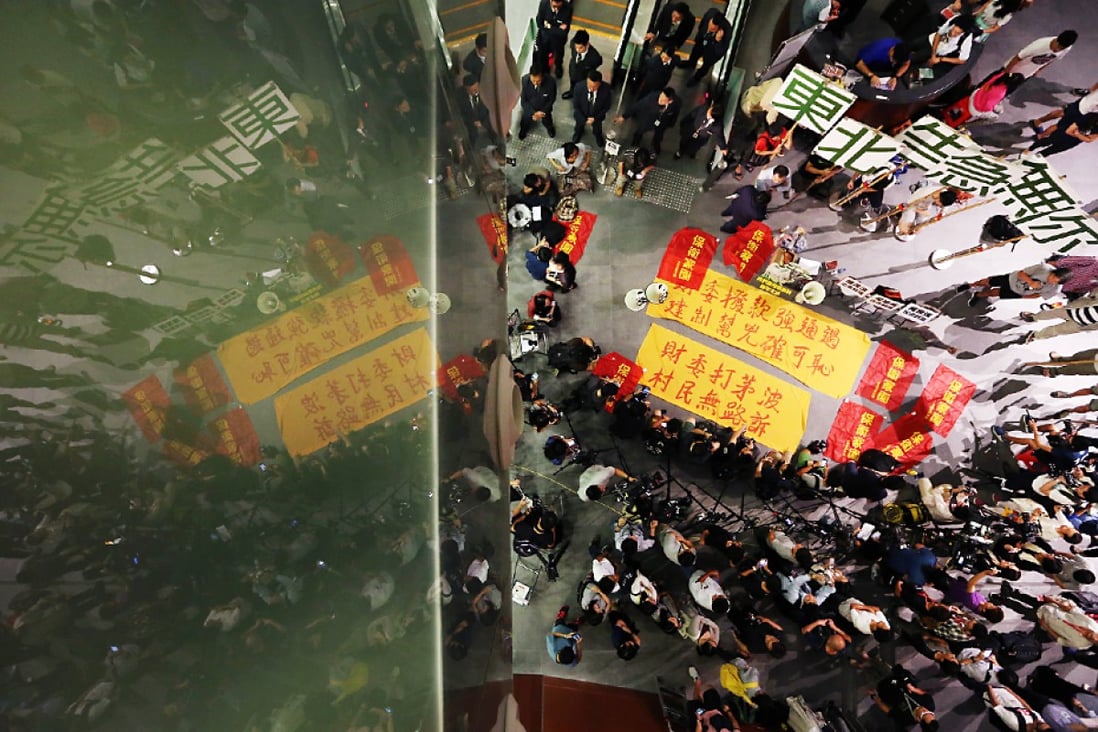 Opponents of the northeastern New Territories development plan protest on the ground floor of the Legco complex. Photo: Felix Wong