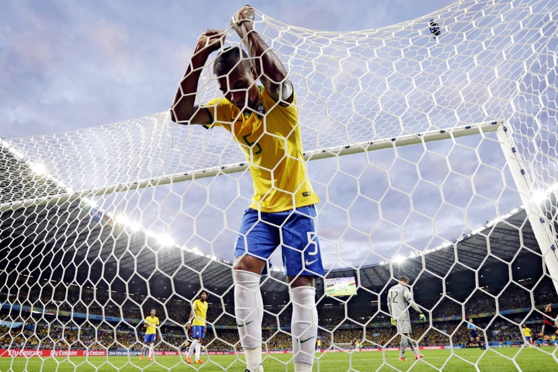 Fernandinho sinks into the net after yet another goal. Photo: AP