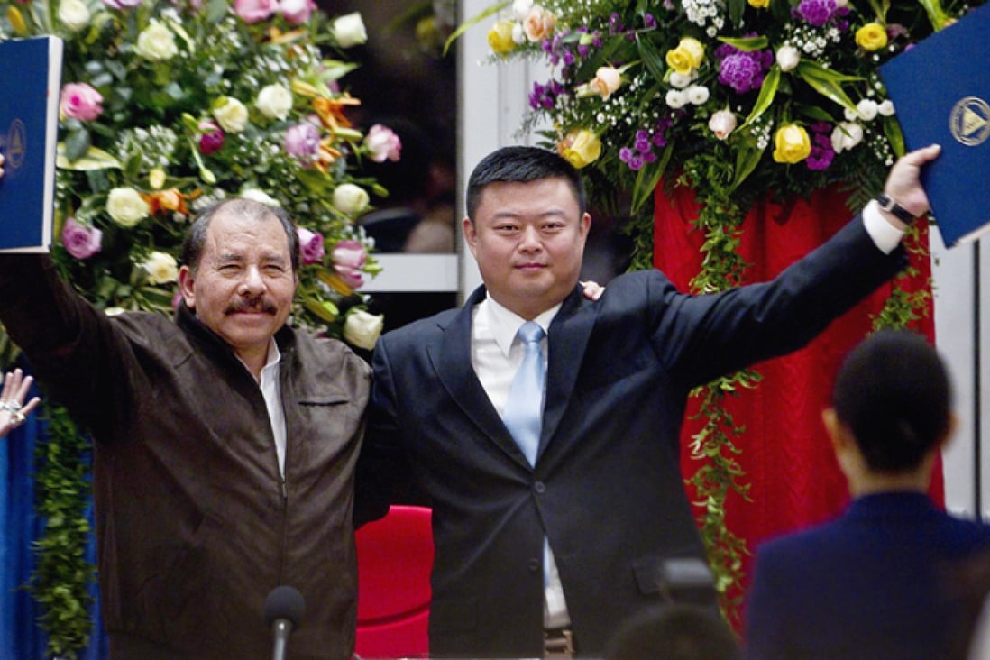 President Daniel Ortega (left) and Chinese businessman Wang Jing hold up a concession agreement for the construction of a multibillion-dollar canal at the Casa de los Pueblos in Managua. Photo: AP