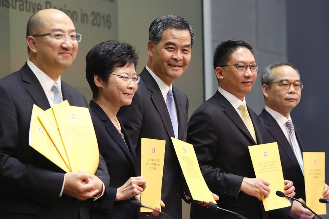 Holding the report (from left) Secretary for Constitutional and Mainland Affairs Raymond Tam; Chief Secretary Carrie Lam; Leung Chun-ying; Justice Secretary Rimsky Yuen; and Undersecretary for Constitutional and Mainland Affairs Lau Kong-wah. Photo: Sam Tsang