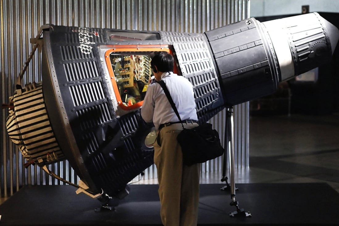 A visitor inspects a replica of a Mercury spacecraft during the 'Space Expo 2014' in Japan. The exhibition presents the history of space exploration by NASA and Japan's national aerospace agency Jaxa. Photo: EPA