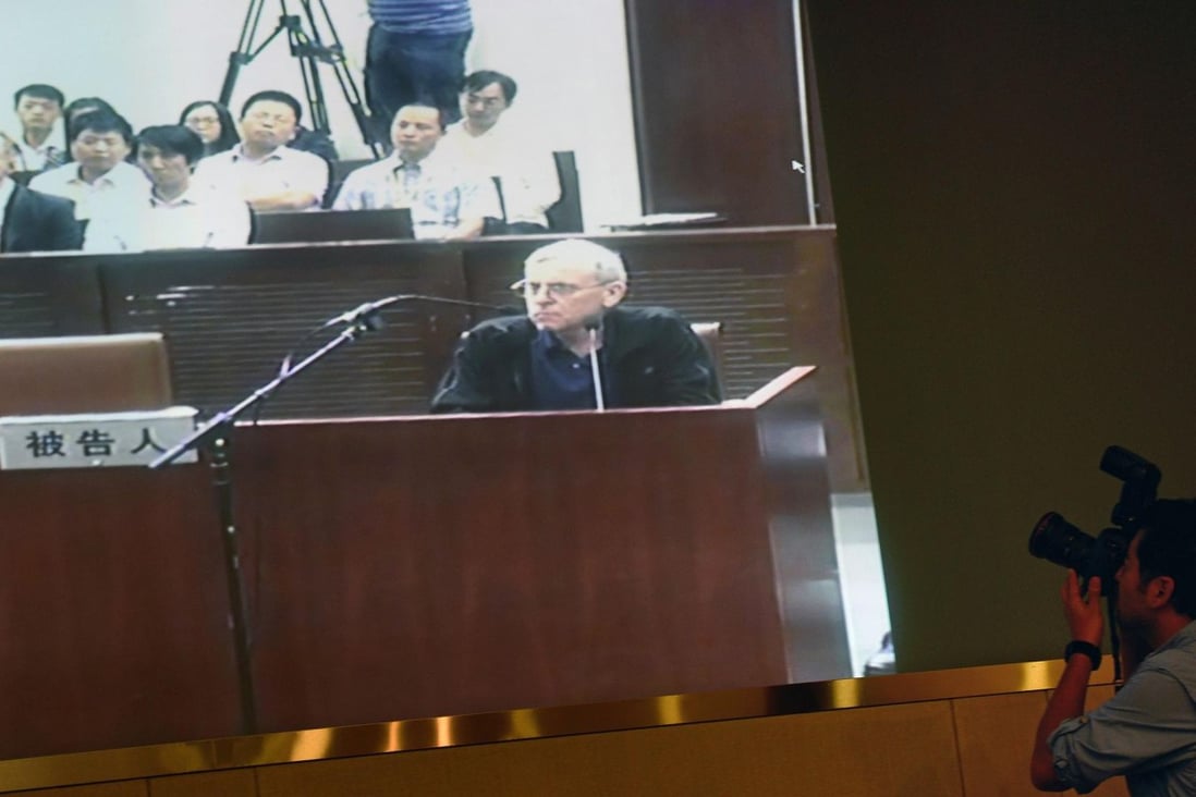 A television screen shows British investigator Peter Humphrey (centre) at his trial on charges he breached China's privacy laws. Photo: AFP