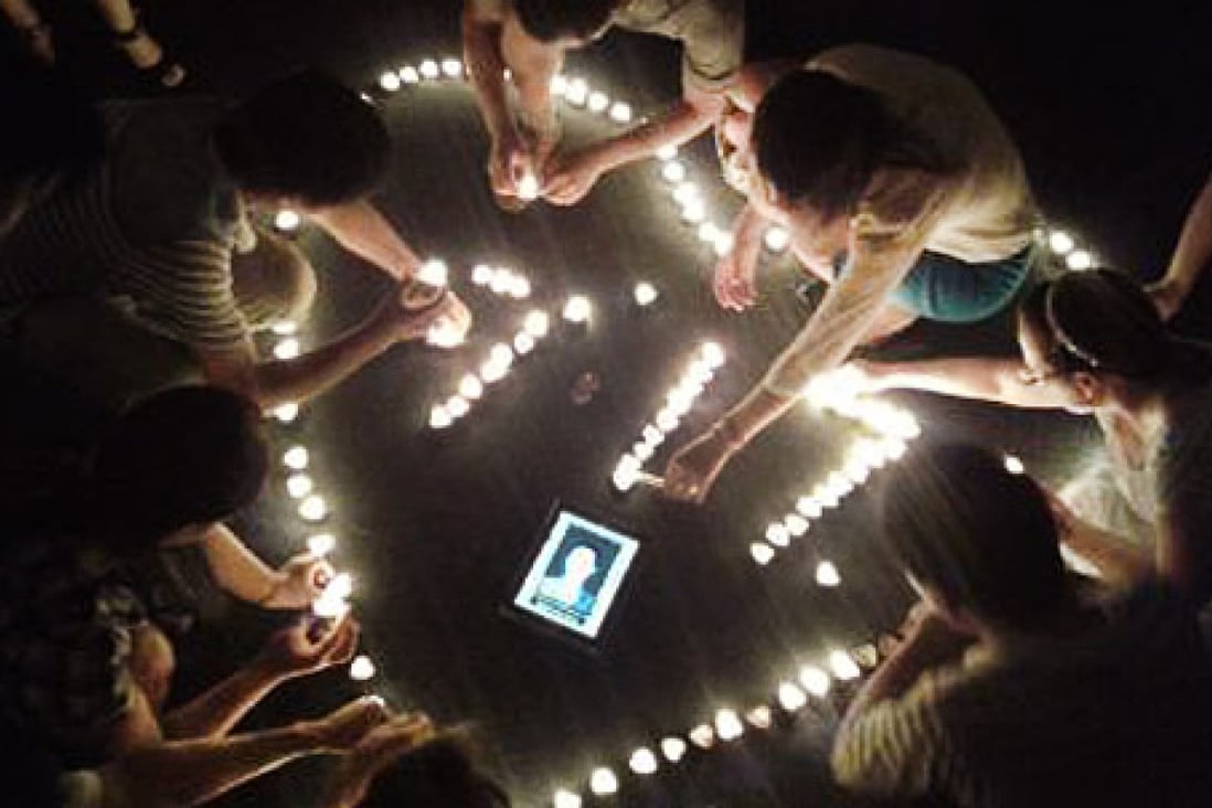 Members of the Shenzhen Chunfeng Labour Disputes Centre participate in a candlelit vigil for Zhou Jianrong, a migrant worker who committed suicide on July 17, 2014. Photo: SCMP Pictures