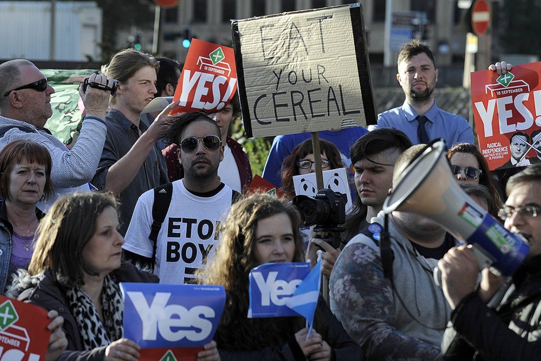 Protesters hold Scottish independence referendum banners from the 'Yes' campaign outside the venue where Britain’s Prime Minister David Cameron was to address the CBI Scotland Annual Dinner in Glasgow on August 28. Photo: AFP