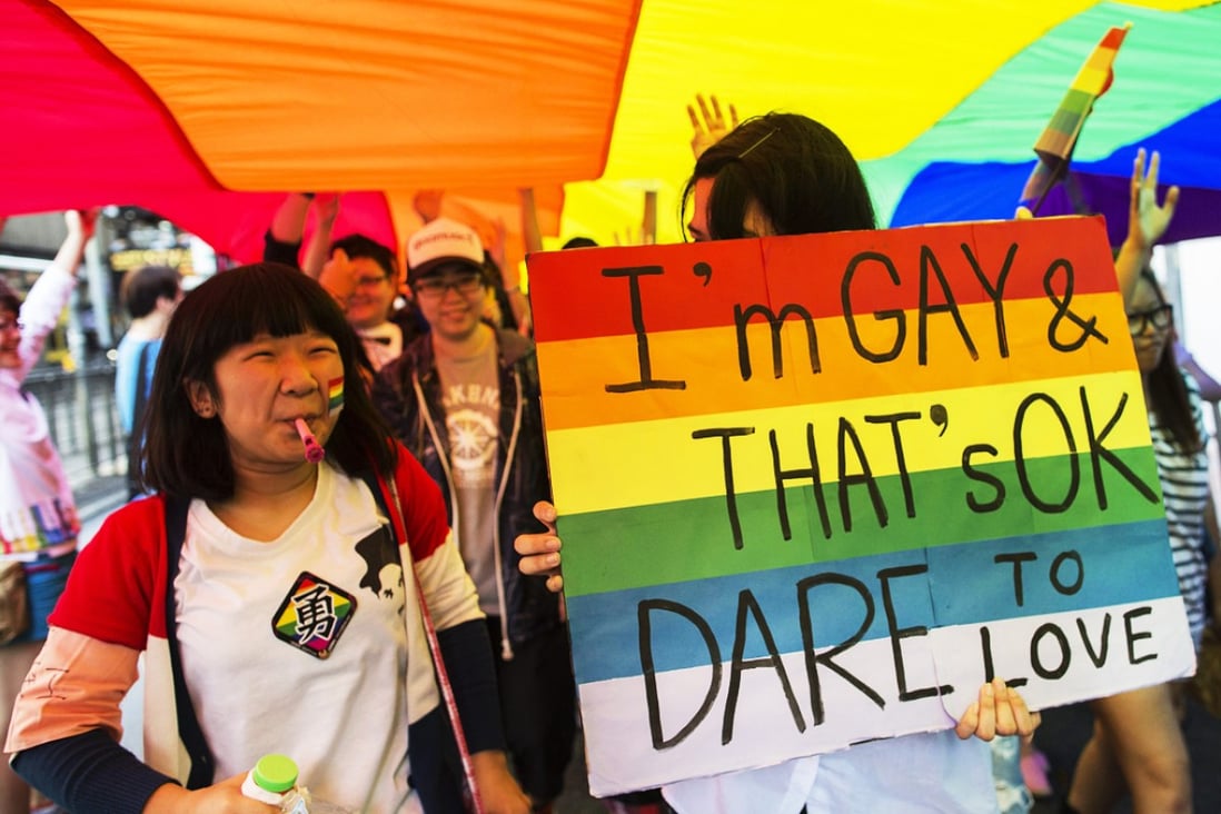 Demonstrators walk under a giant rainbow flag and chant slogans during a gay pride parade in China. Photo: EPA