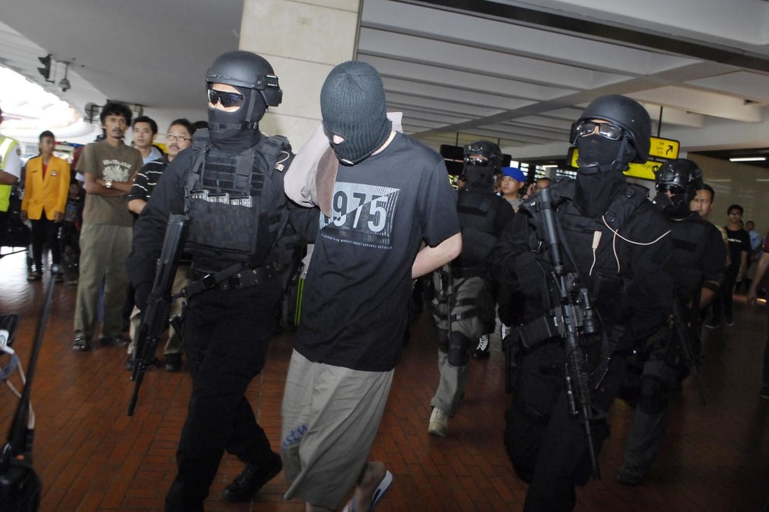 Elite Indonesian anti-terror police escort the four ethnic Uygur suspects through Jakarta airport after their arrest on Saturday. Photo: AFP