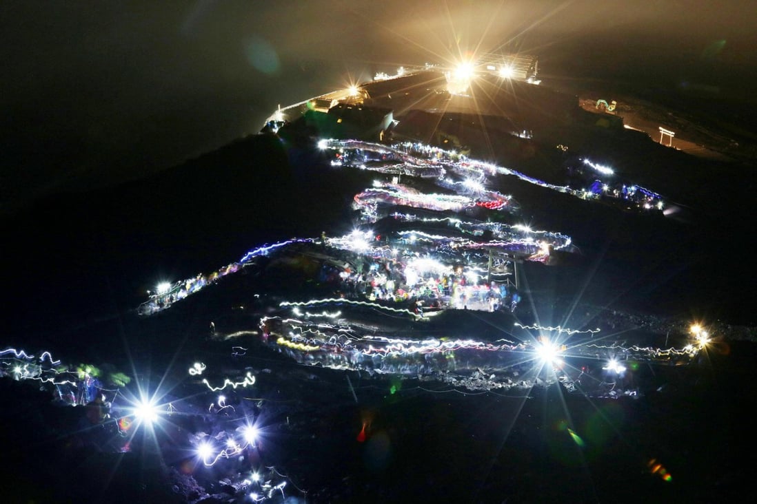 Flashlights trace a line of climbers hiking to Fuji's summit. Photo: AFP