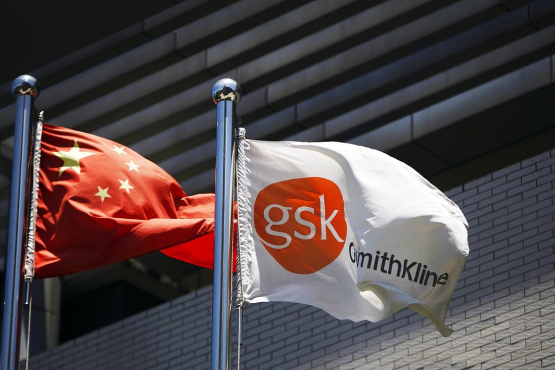 A flag bearing the logo of GlaxoSmithKline (GSK) flutters next to a Chinese national flag outside a GlaxoSmithKline office building in Shanghai. Photo: Reuters 