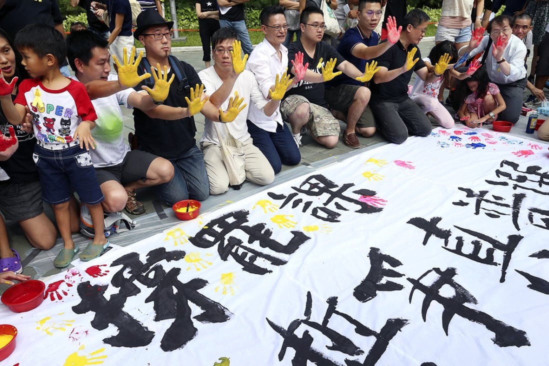 Former students put their hand prints on a banner at Tamar Park backing the class boycott by students. Photo: K.Y. Cheng