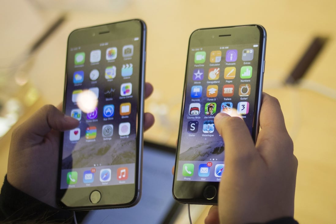 A customer holds an iPhone 6 (right) and iPhone 6 Plus. Photo: Reuters