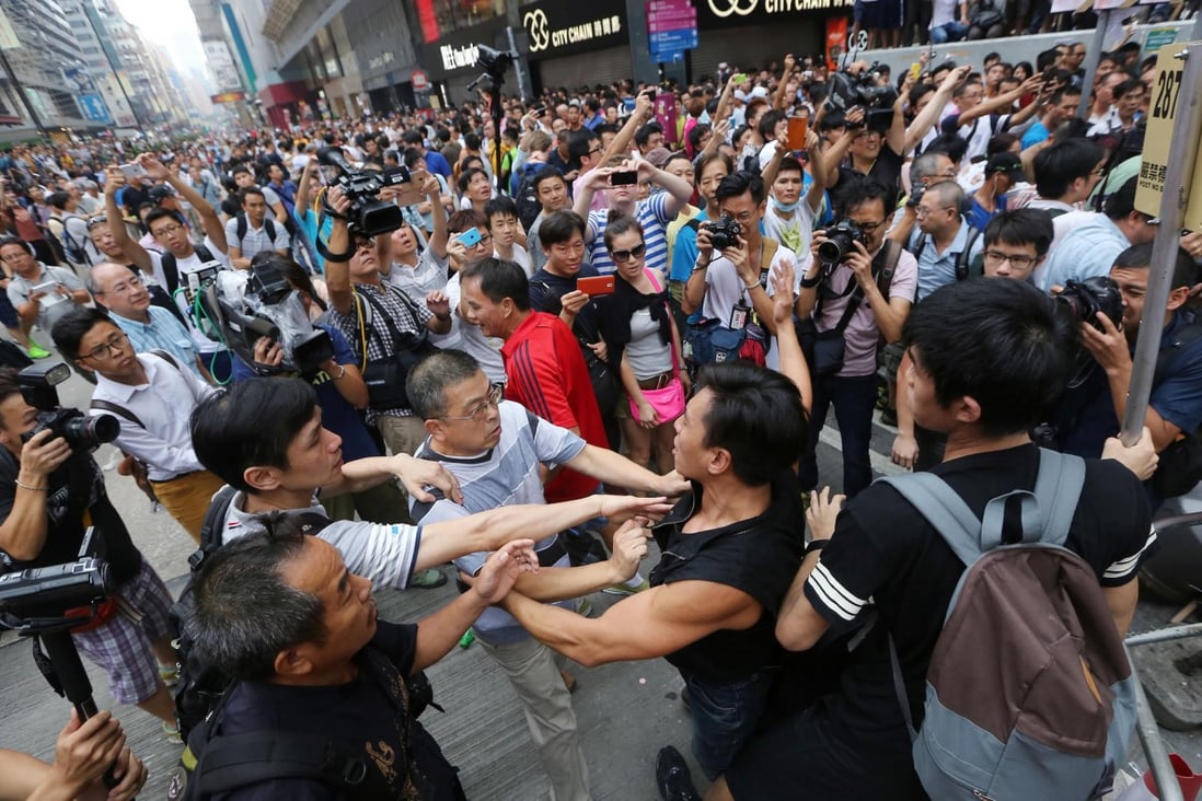 Pro-democracy demonstrators clash with anti-Occupy protesters in Mong Kok yesterday. Mainland media warn of economic losses to the city. Photo: Sam Tsang