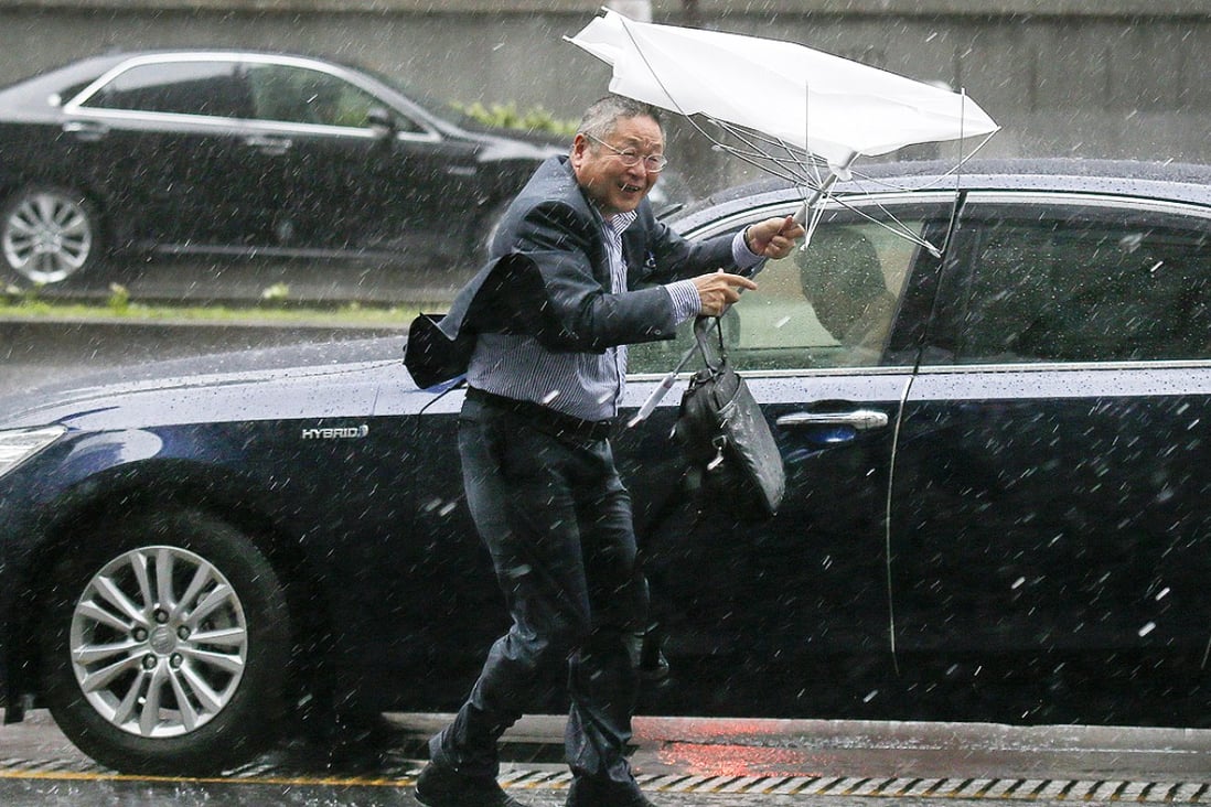 A businessman struggles with his umbrella during heavy rain in Tokyo,on Monday morning as Typhoon Phanfone strikes Japan. Photo: EPA
