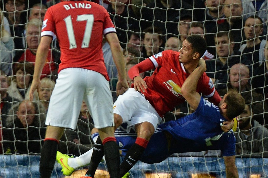 United's Chris Smalling pulls Chelsea's Branislav Ivanovic to the ground in the Manchester United penalty area. The ref did not award a penalty spot kick. Photo: EPA