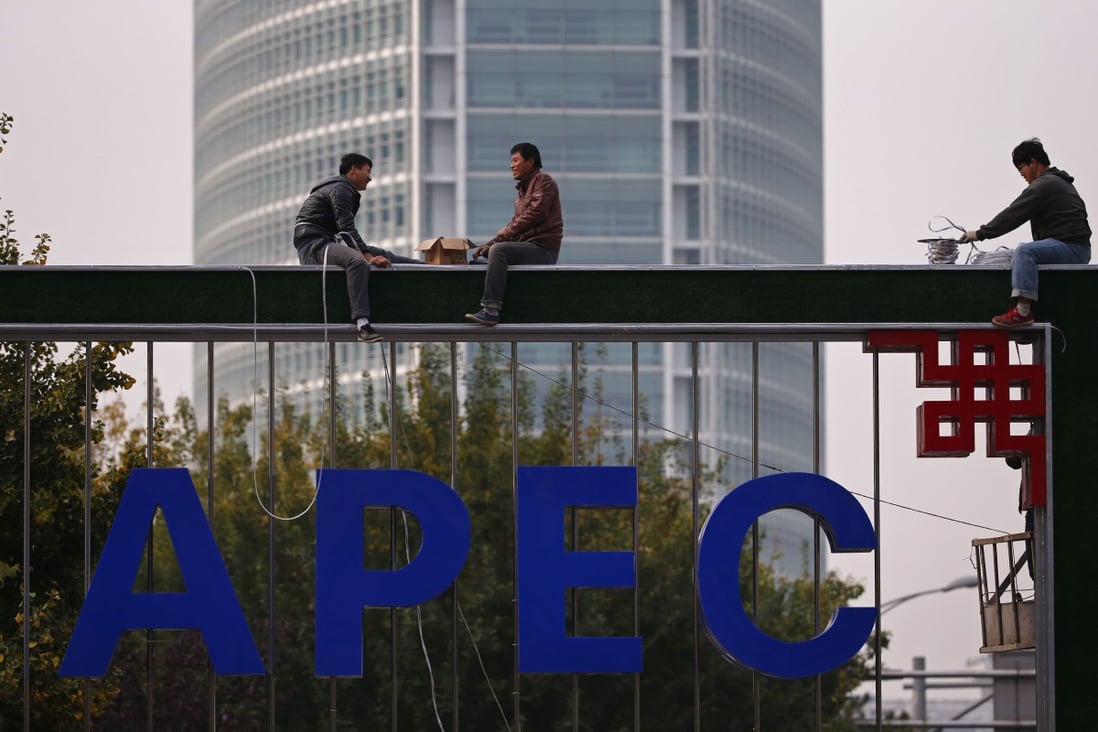 Workers install lighting on an APEC sign post at the financial district in Beijing. Photo: Reuters