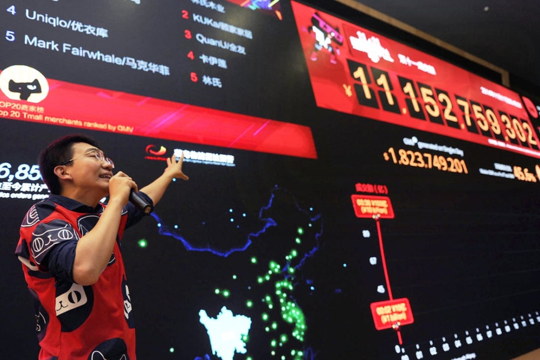 An employee at Alibaba headquarters in Hangzhou draws attention to the rising Double 11 sales. "Singles Day" is the mainland's busiest online shopping day. Photo: Xinhua