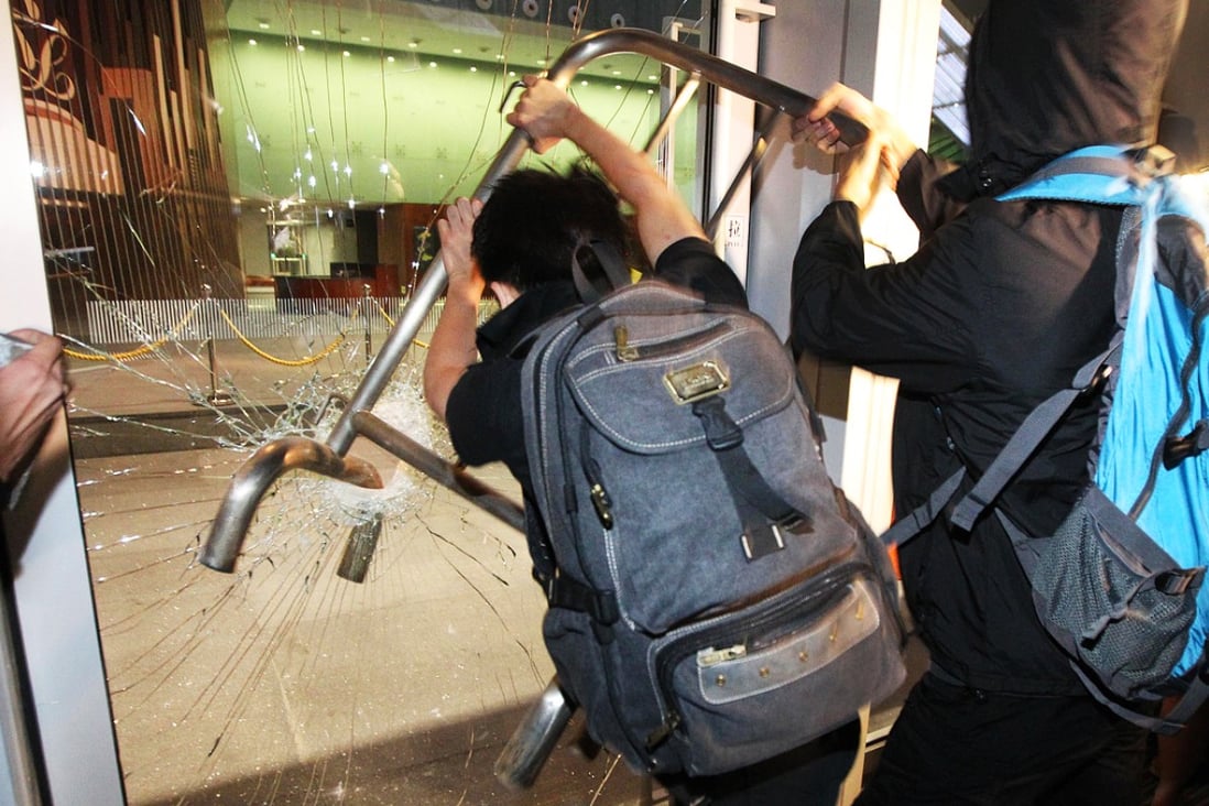 Protesters smash glass doors at the Legco complex. Photo: SCMP Pictures
