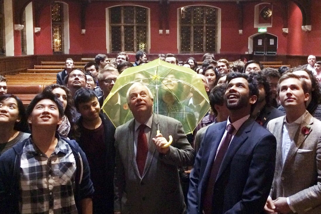 In this picture taken on October 31, 2014, Hong Kong's last British governor Chris Patten, holds a yellow umbrella - a symbol of the Occupy movement in Hong Kong - after it was given to him by a University of Oxford student in the audience during an event at the Oxford Union in Oxford.  Photo: AFP