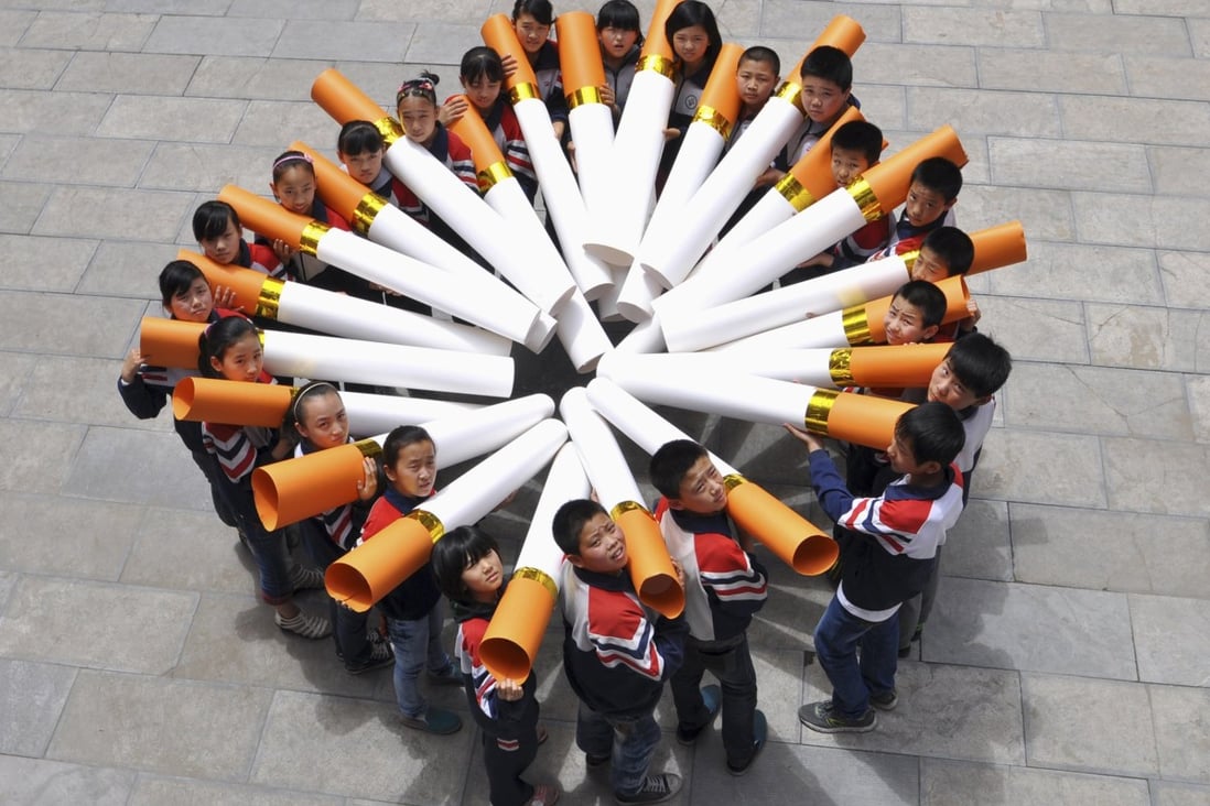 Primary school students pose for pictures with big cigarettes ahead of World No Tobacco Day last year. Photo: Reuters