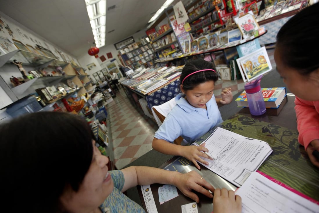 Bookshop owner Helen Duong helps schoolgirls with their homework at her store in Alhambra, California. Photo: TNS