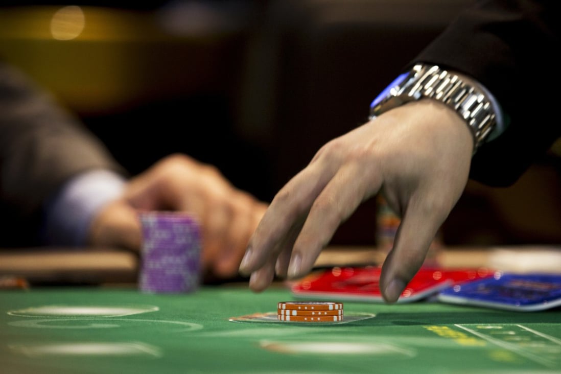 A crouper collects gaming chips at a Macau casino as gaming revenues in November fell for the sixth month running. Photo: Bloomberg