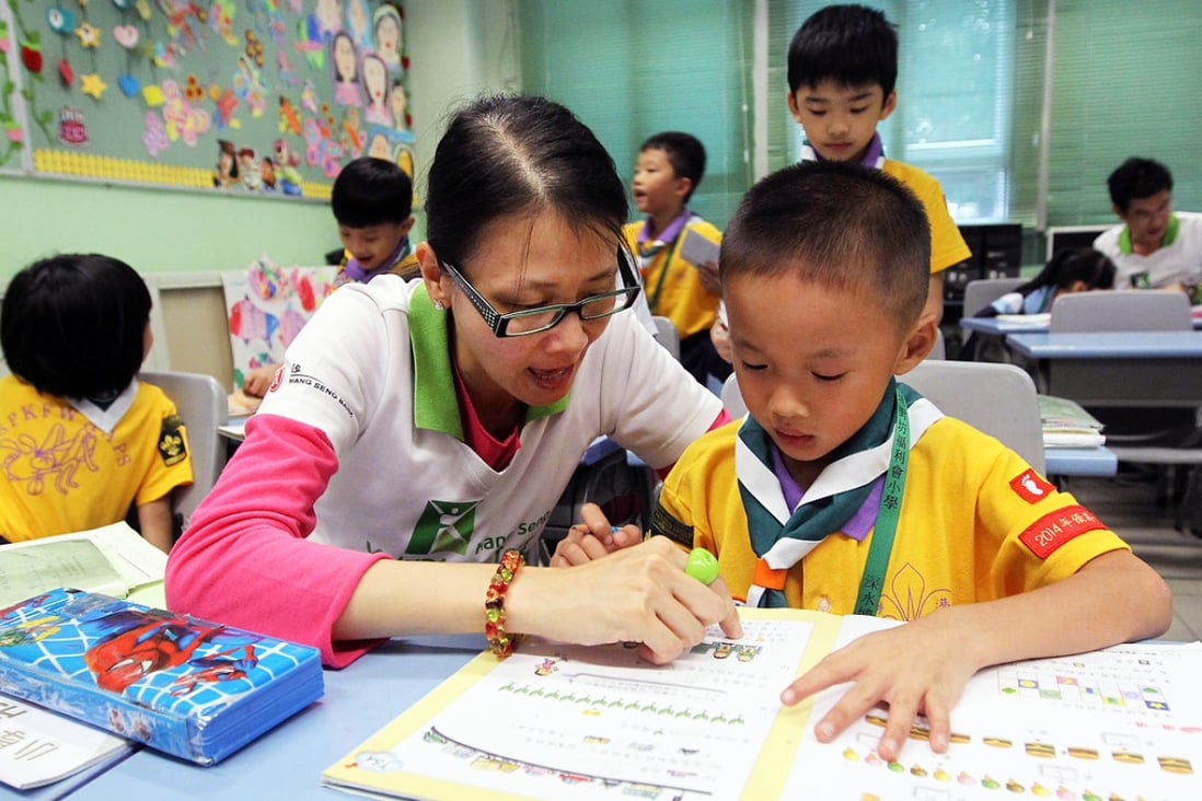 Hang Seng team volunteer Kitty Lai Man-ying helps primary school pupil Lee kit-ho. Photo: Edward Wong