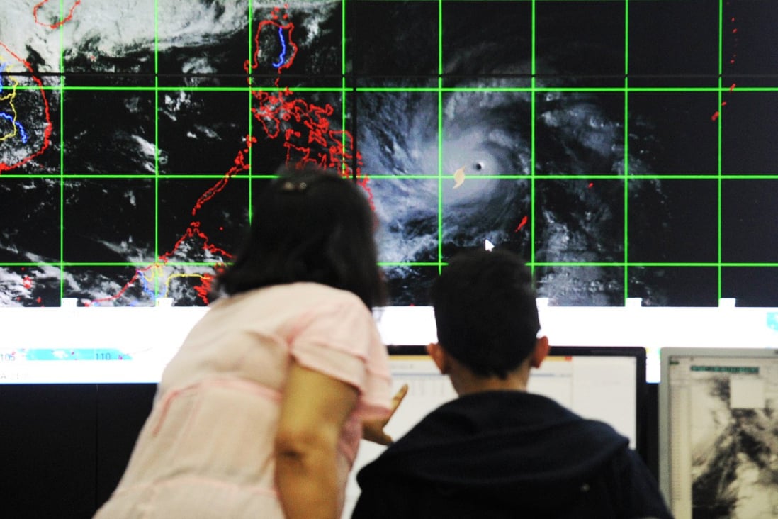 Meteorologists from the Philippine Atmospheric, Geophysical and Astronomical Services Administration plot the direction of Typhoon Hagupit from Manila. Photo: AFP