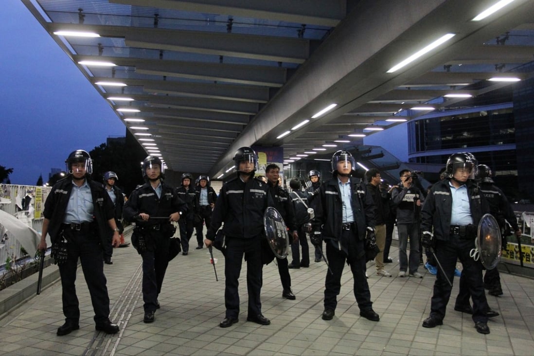 Police stand guard as they face a crowd of pro-democracy protesters in Tamar. Photo: May Tse