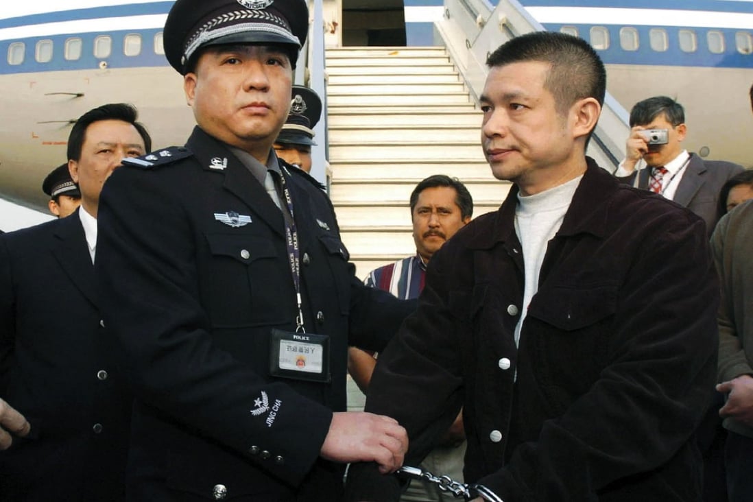 Fugitive suspect Yu Zhendong (right), suspected of stealing millions of yuan from a Chinese state-owned bank, is detained by Chinese police after being returned by United States authorities in 2004. Photo: AP