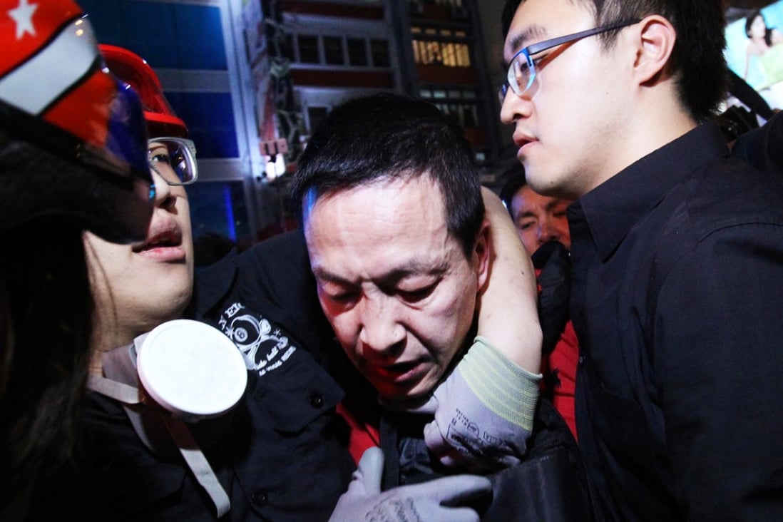 Ma Hei-yuk, 45, is subdued by protesters at the Mong Kok site on October 22. Photo: Dickson Lee