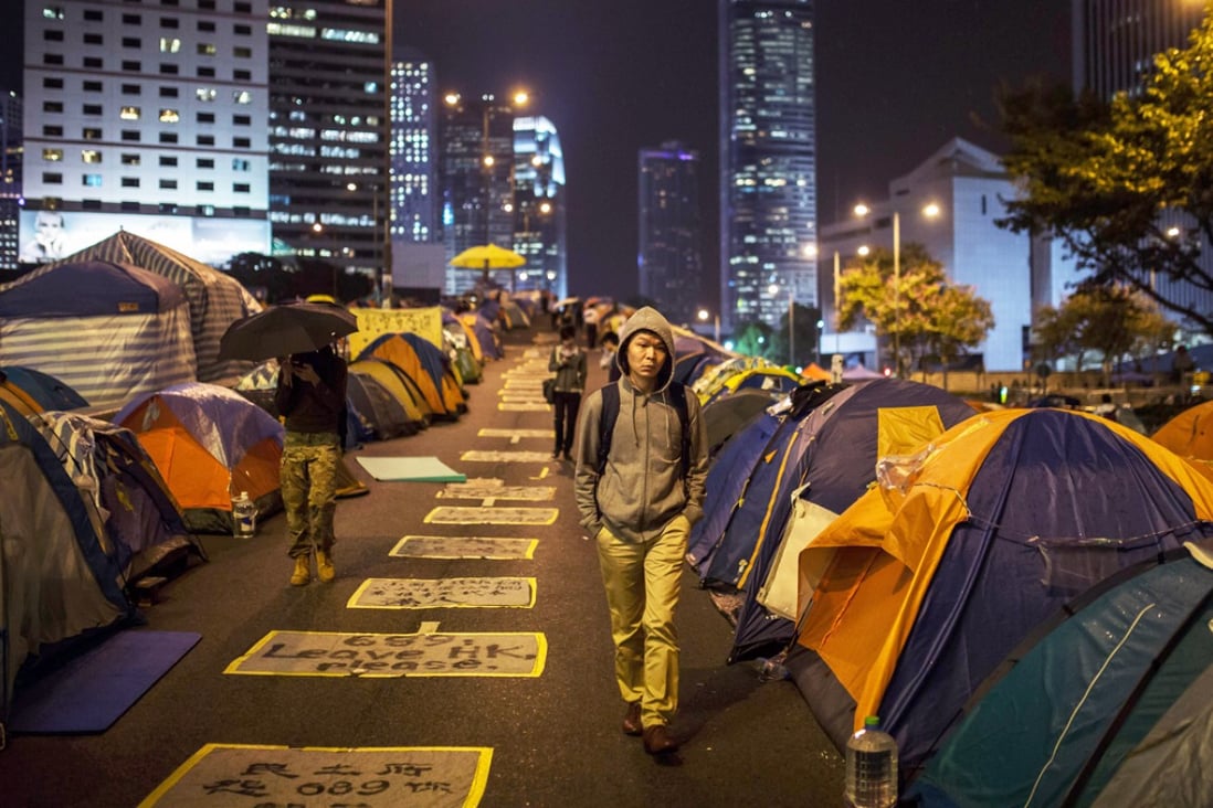 Pedestrians and protesters walk on a section of Harcourt Road, a multi-lane highway through the heart of the financial district currently blocked by pro-democracy protester barricades and hundreds of tents. Photo: AFP