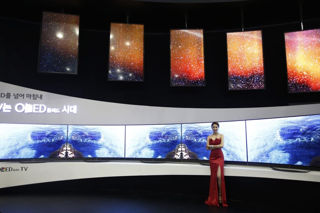A model poses in front of LG Electronics' flexible organic light-emitting diode (OLED) TV sets, which are made with LG Display flat screens, during the 2014 Korea Electronics Show in Goyang October 17, 2014. Photo: Reuters
