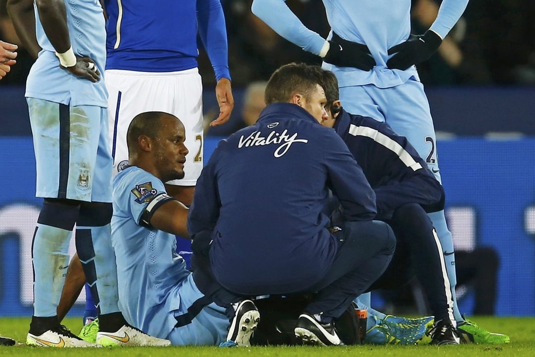 Vincent Kompany is assessed by medical staff after straining a hamstring during Manchester City's 1-0 win over Leicester City. Photo: Reuters