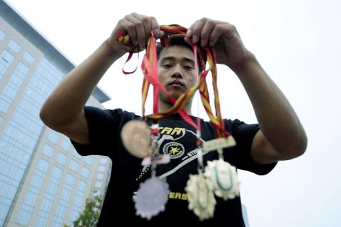 Former gymnastics champion Zhang Shangwu is back performing stunts on the streets - this time in the Shanghai subway. Photo: SCMP Pictures
