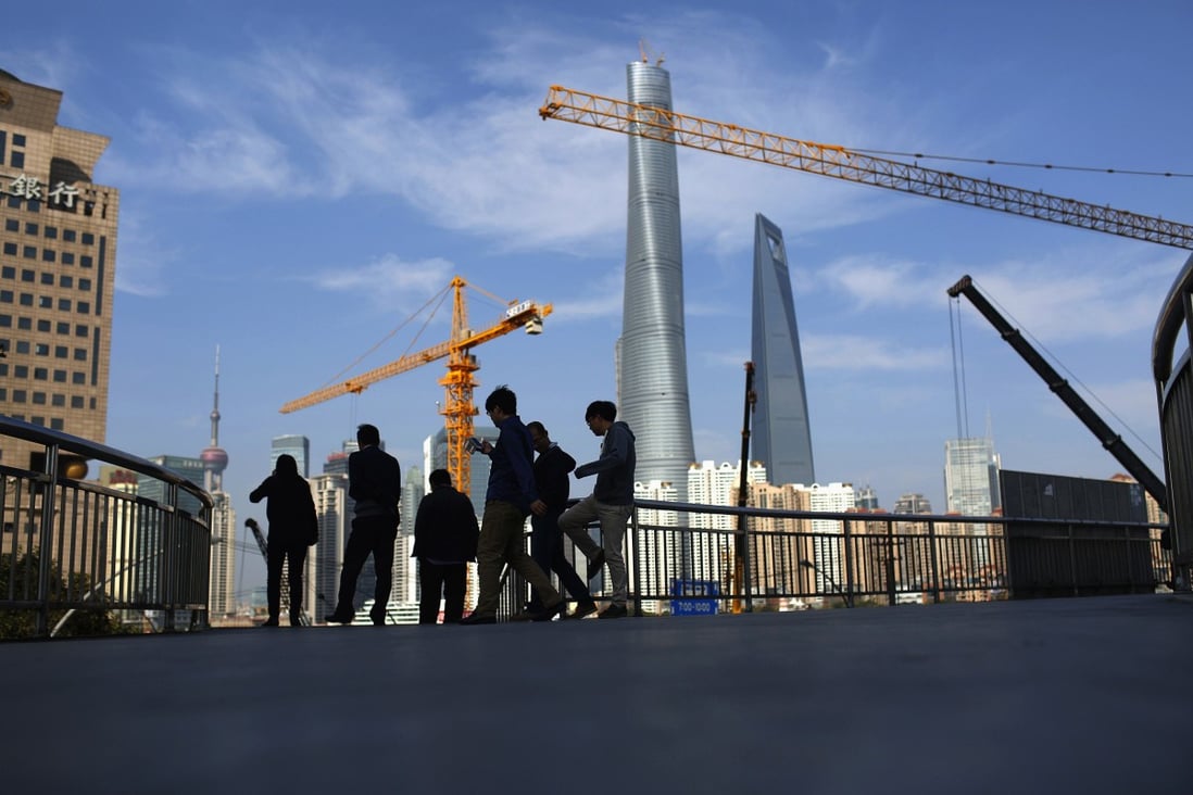 People walk on a bridge near the financial district of Pudong in Shanghai November 21, 2014. Photo: Reuters