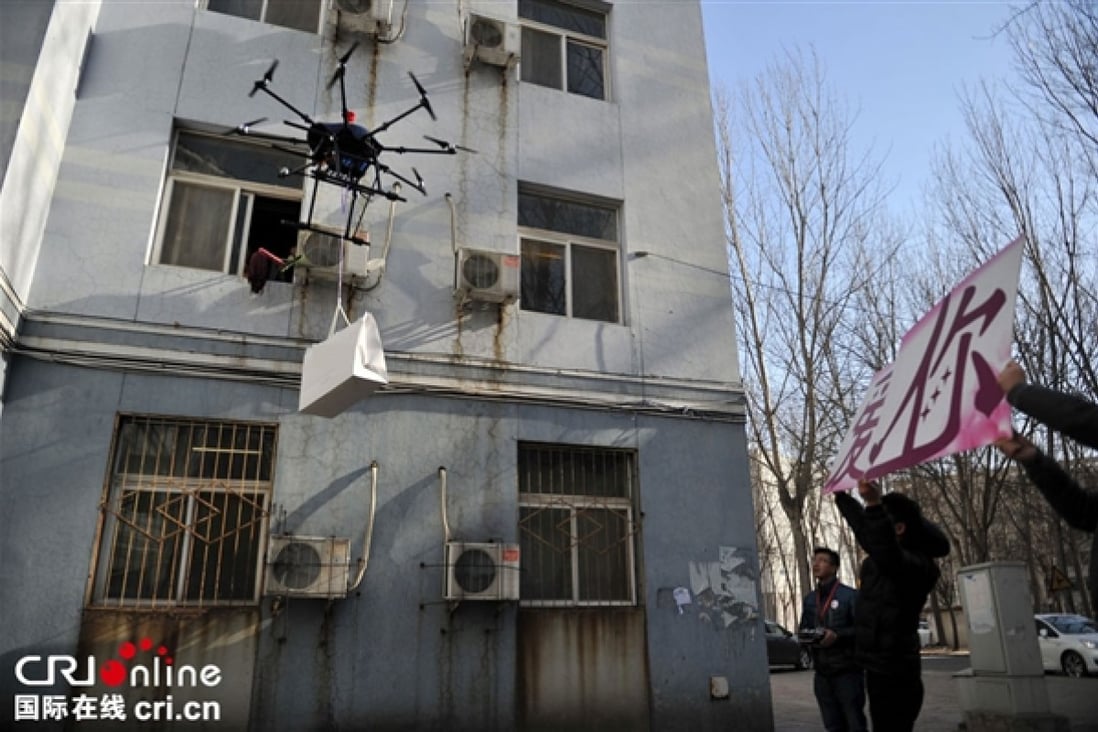The would-be Chinese 'Romeo' flies a drone carrying a luxury bag up to the window of his 'Juliet', as his friends hold up a sign declaring his love.  Photo: cri.cn
