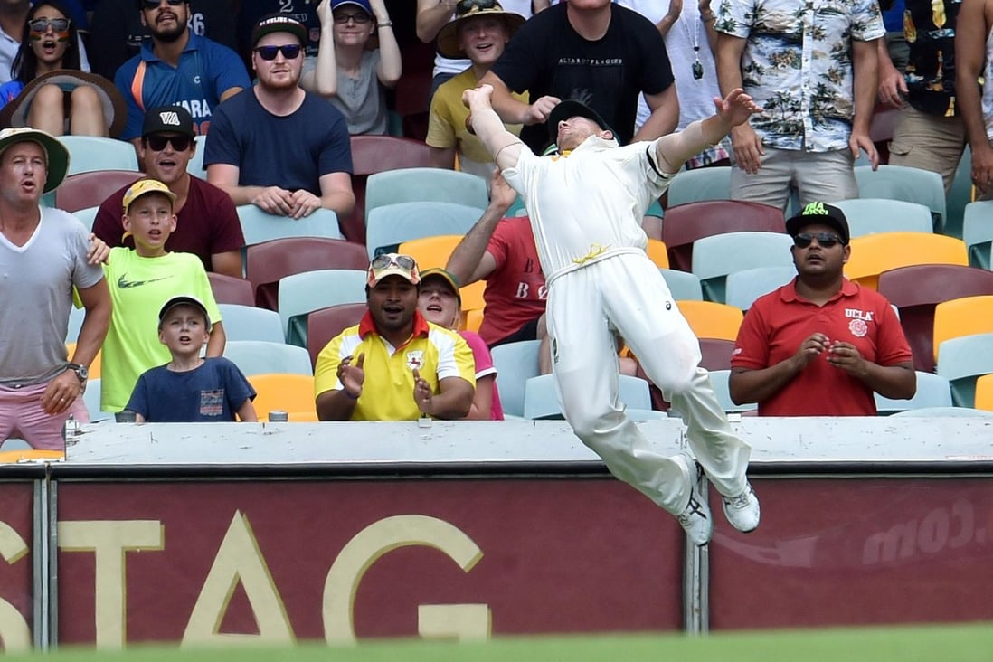 Australia's David Warner dives as he tries to take a catch on the boundary on day four of the second test against India. Photo: AFP