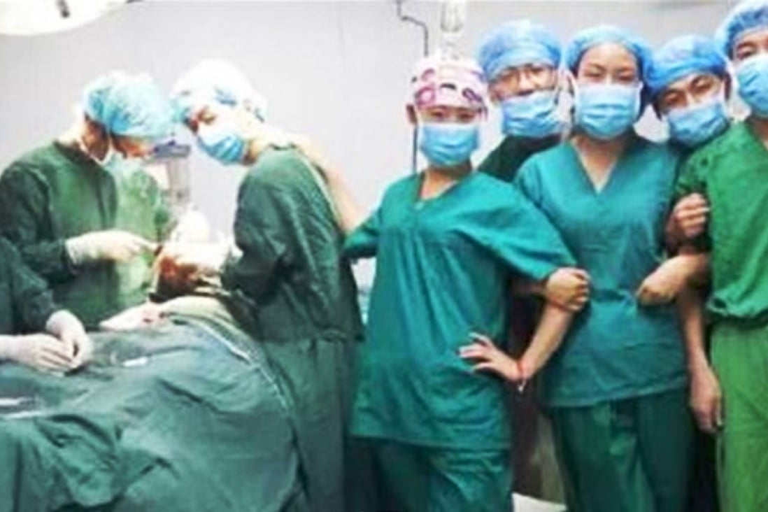 Say cheese: one of the photos of Chinese doctors and nurses taken during an operation at a Xian hospital, which sparked public anger. Photo: www.qianzhan.com