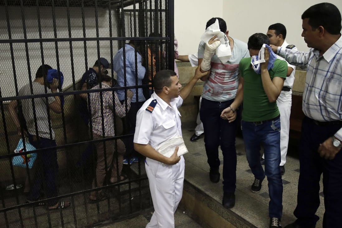 In a related case, eight Egyptian men convicted for "inciting debauchery" over an alleged same-sex wedding on a yacht are led to a courtroom. Photo: AP