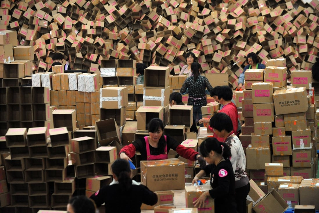 Chinese workers package products from online orders at the warehouse of an online snack vendor in Changxing county, Zhejiang Province. Photo: ImagineChina 