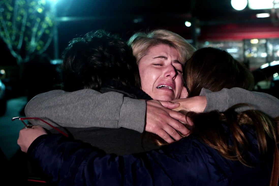 A survivor of the ferry "Norman Atlantic" reacts as she hugs her children after arriving at the Elefsina military airport in Athens. Photo: AFP
