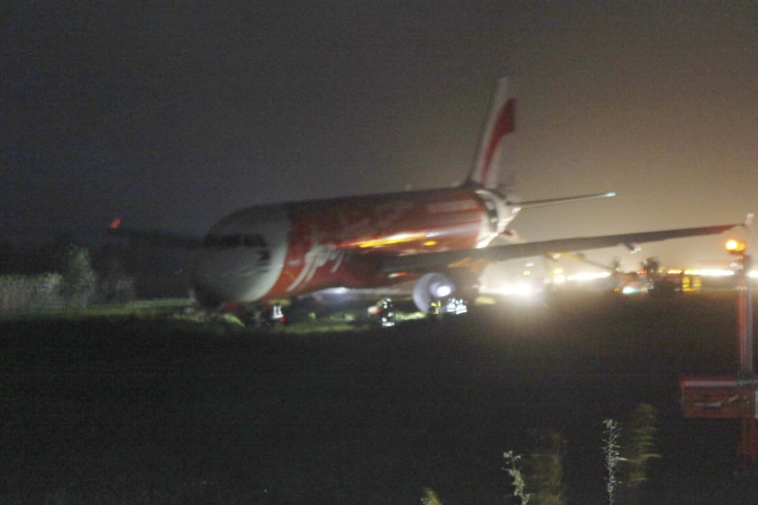 An AirAsia passenger plane sits on the grassy portion of the runway after overshooting upon landing in windy weather at Kalibo airport in central Philippines. Photo: AP