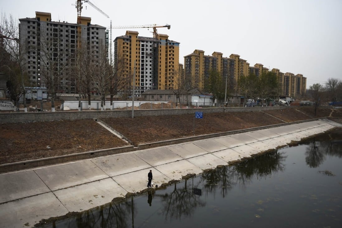 Newly built apartments dwarf a man fishing nearby in Beijing as land buying first-tier cities like the Chinese capital is seen staying strong. Photo: AFP