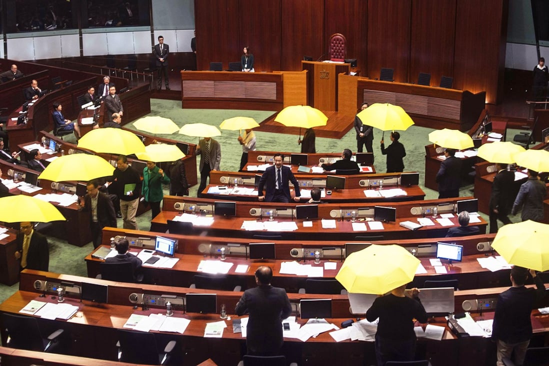 Pro-democracy legislators holding yellow umbrellas walk out of the  Legislative chamber to show their protest on January 7, 2015. Photo: AP