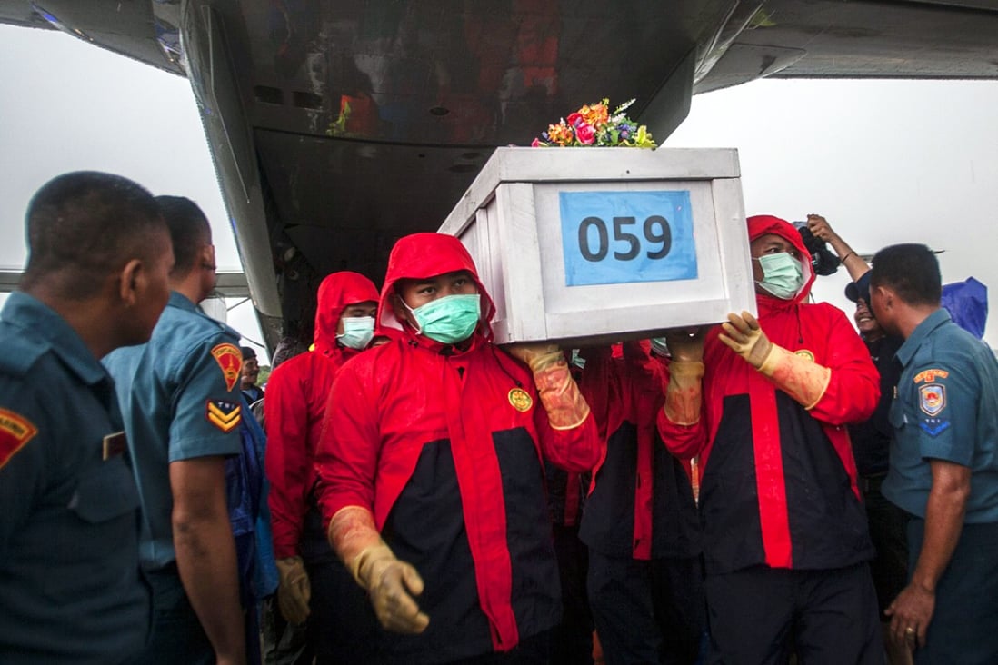 Indonesian rescue personnel unload a coffin bearing a body recovered from the underwater wreckage of the ill-fated AirAsia flight QZ8501. Photo: AFP
