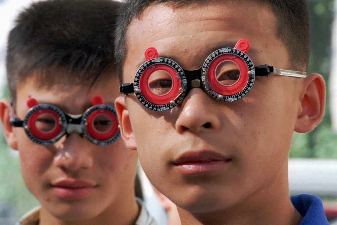 Chinese students have their eyesight tested with temporary lenses by an optician. Photo: Reuters