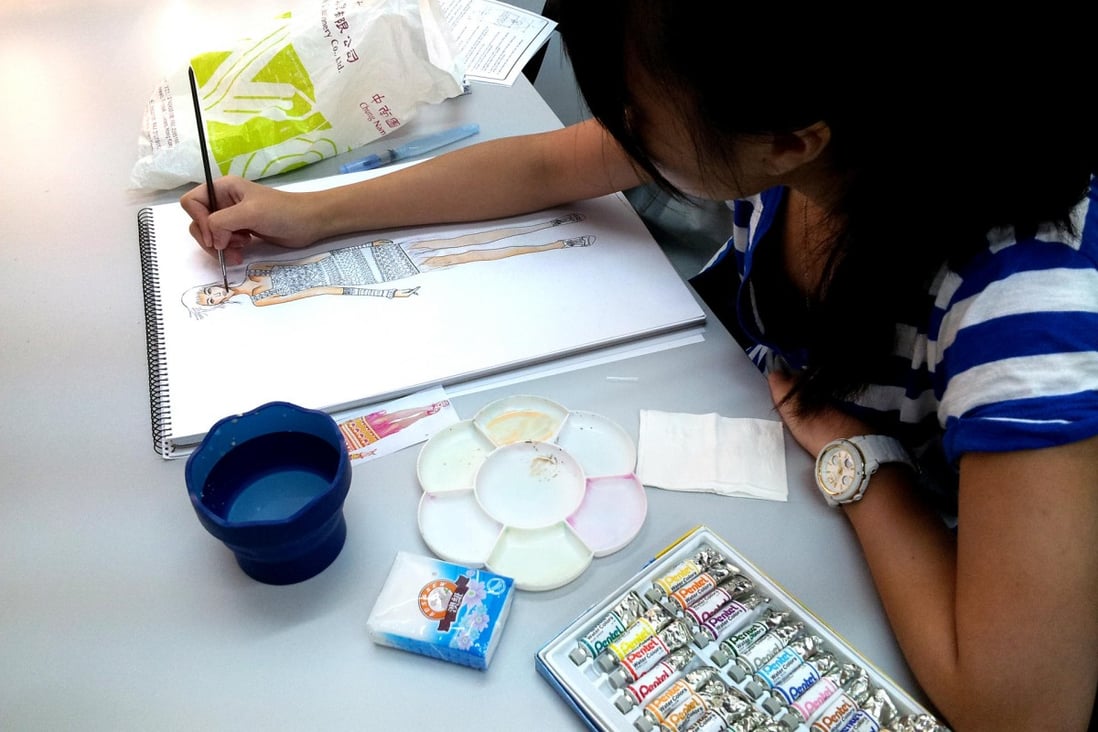 An Academy of Design student works on a sketch.