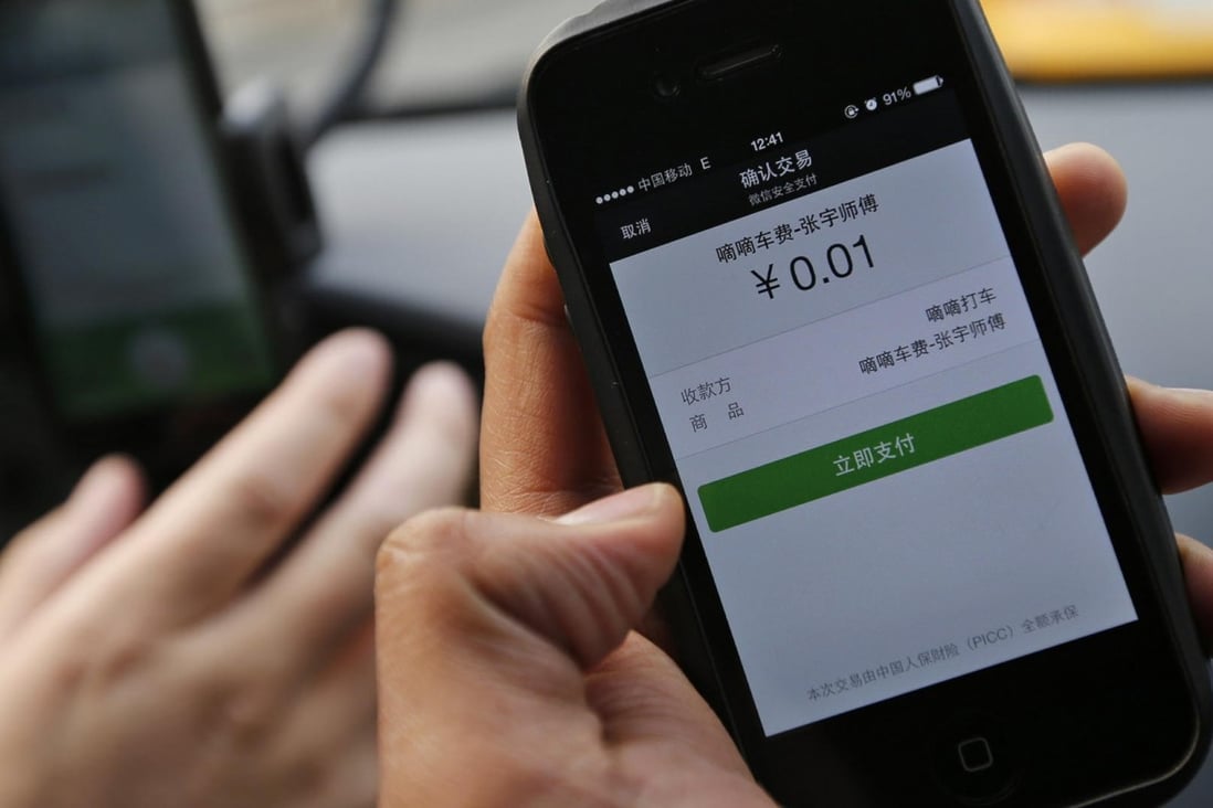 A taxi passenger in Beijing uses the Didi Dache phone app