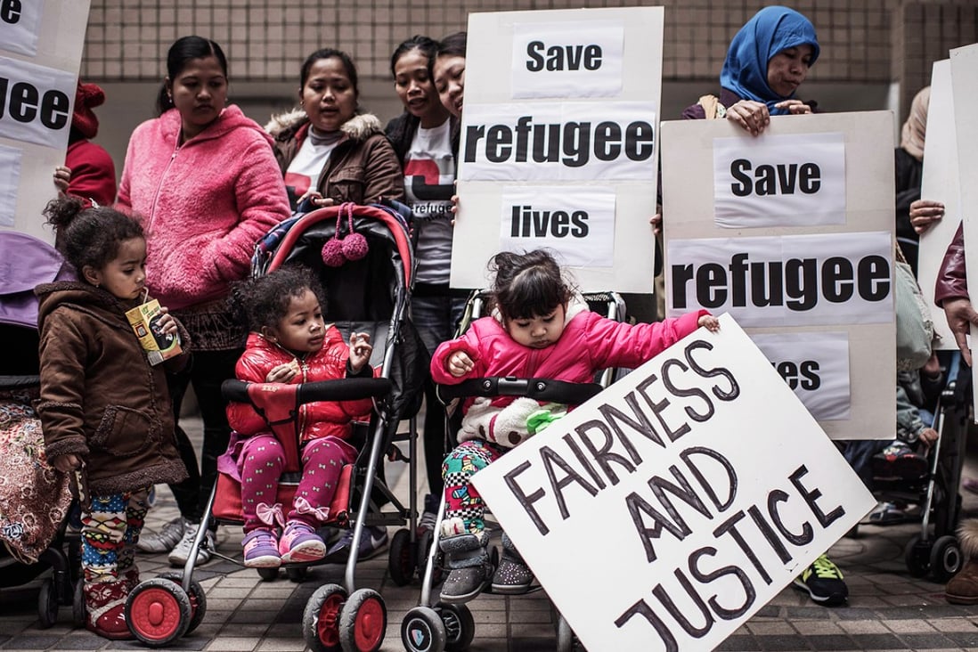 Asylum seekers along with their children stage a protest for their rights in Hong Kong on February 6, 2015, following the recent death of one of them during a fire that broke in a slum. Photo: AFP