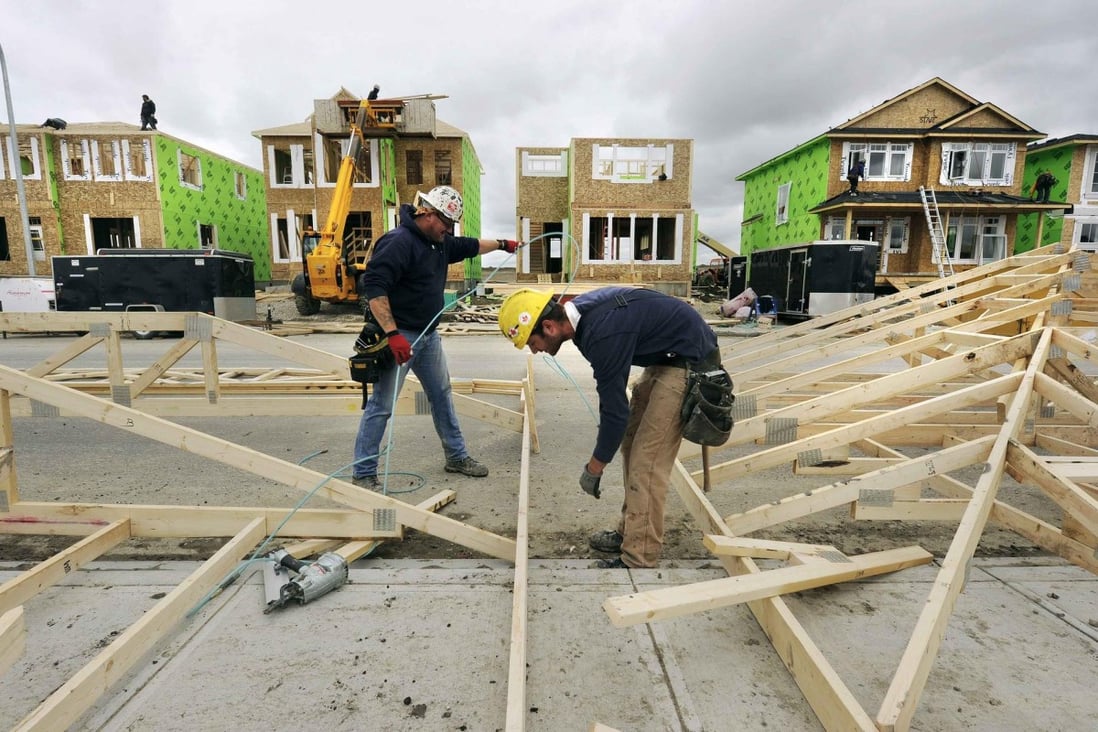 Construction workers build homes in Calgary. Buyers are hoping for a real estate slump. Photo: Reuters